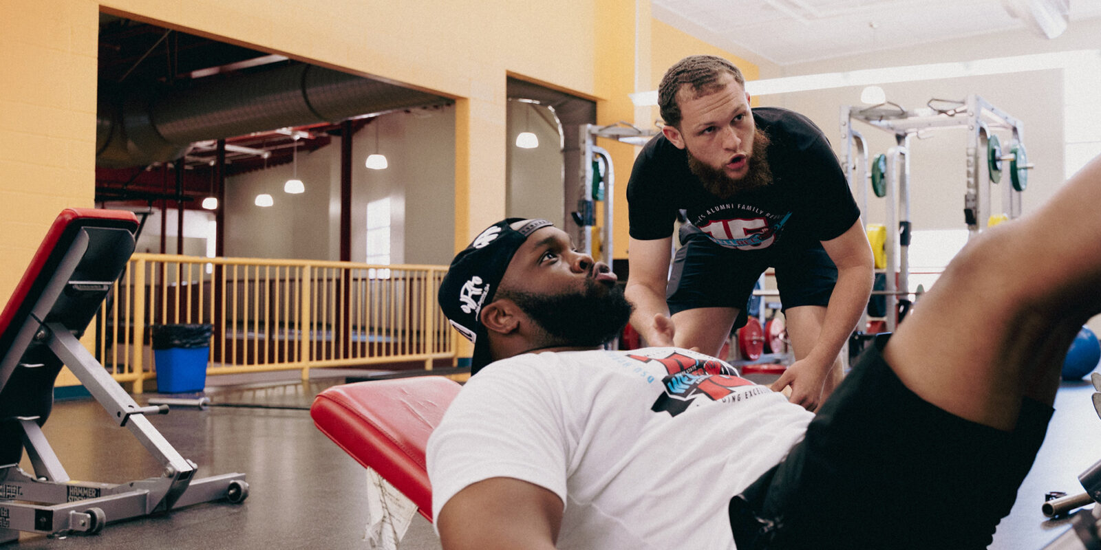 Two young men actively working out at a gym