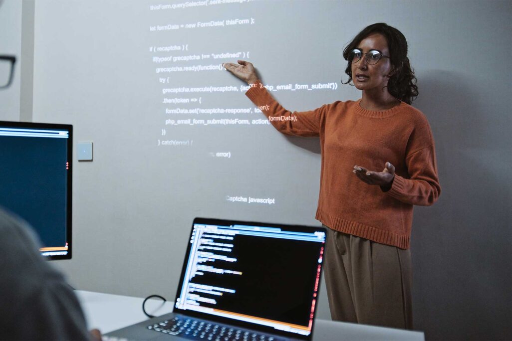 dsu_ms-computer-science_lp_hero Computer science student explaining a line of code from a projection